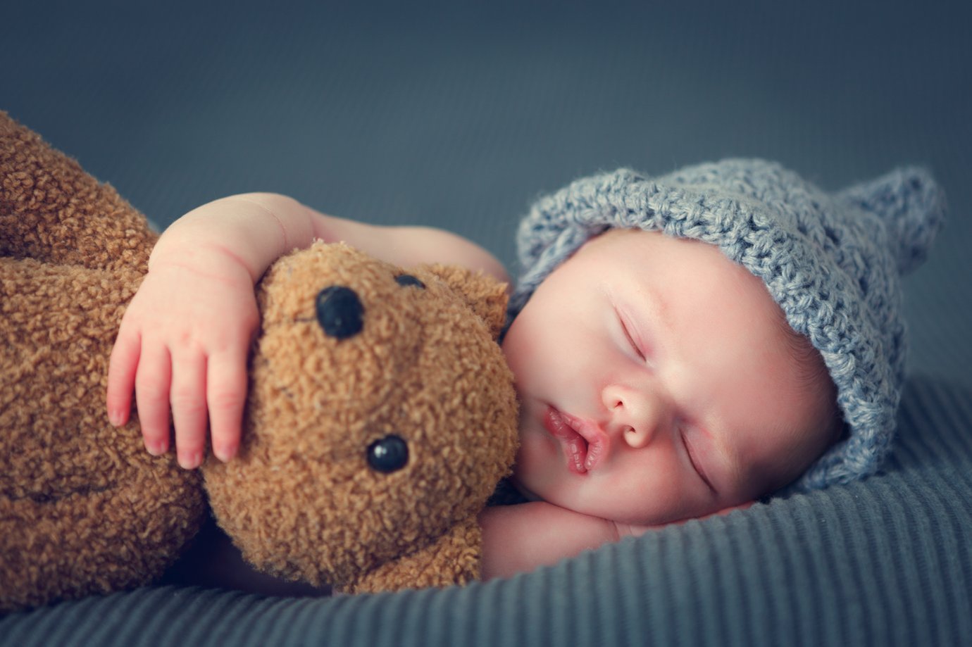 Baby mit Teddy im Arm
